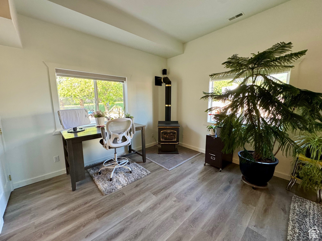 Office space with wood finished floors and a wood stove