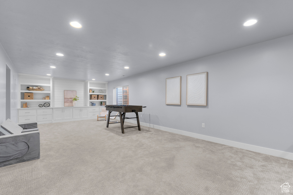 Recreation room with recessed lighting, light colored carpet, and built in shelves