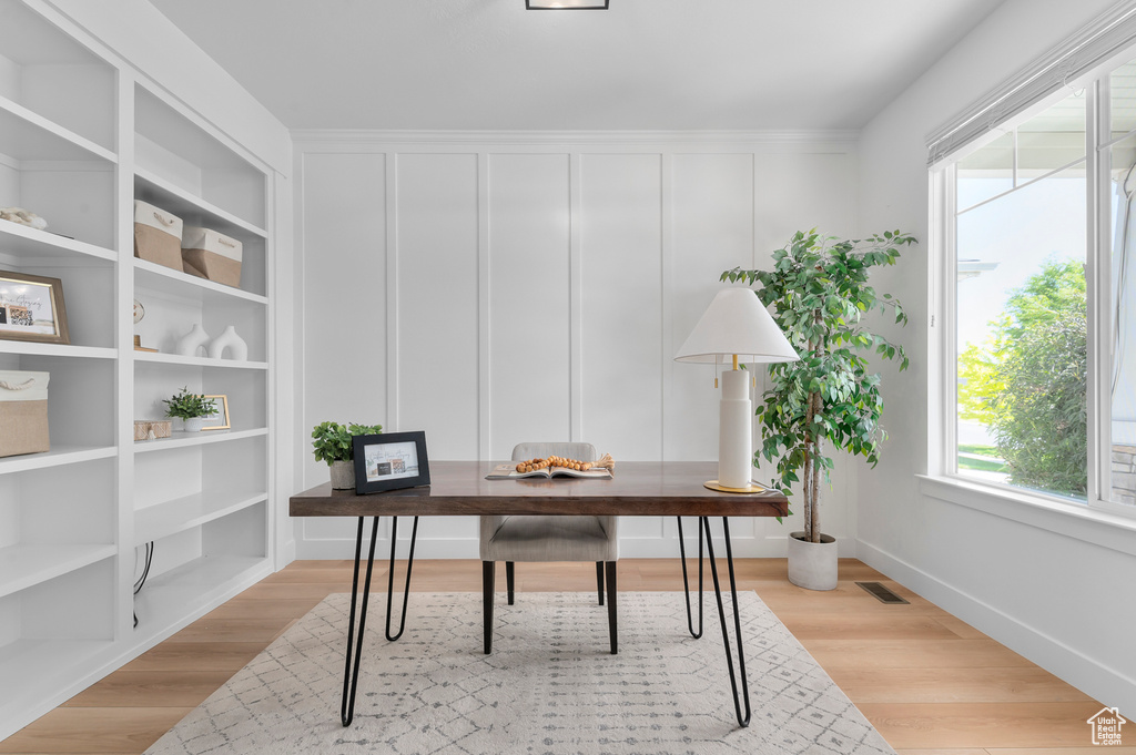 Office space with a decorative wall and light wood-style floors