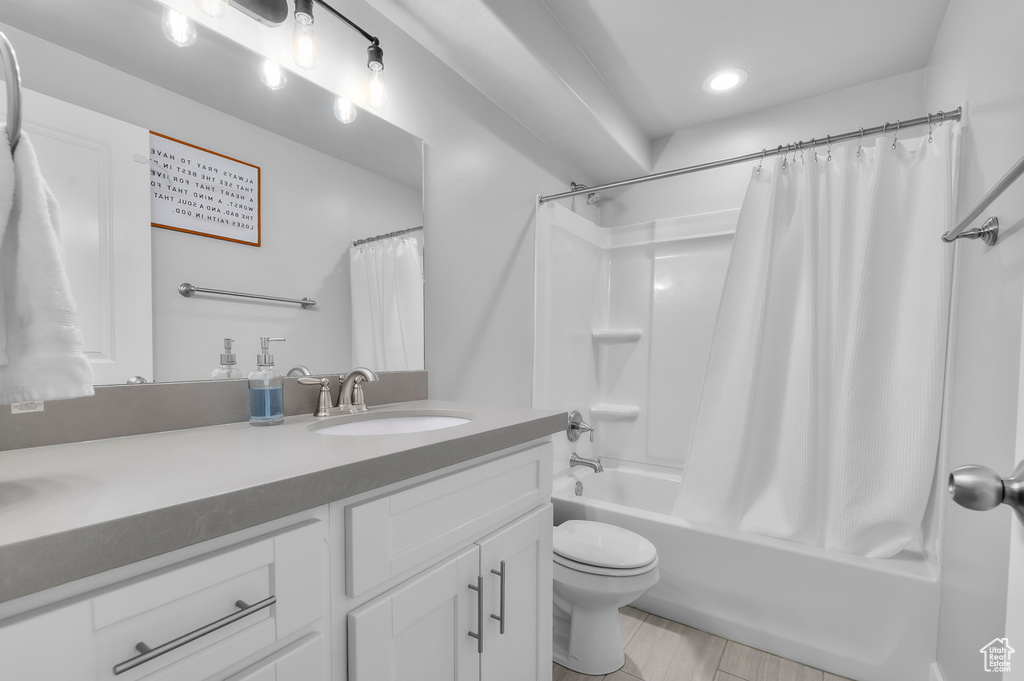 Bathroom featuring double vanity, shower / bath combo, and recessed lighting