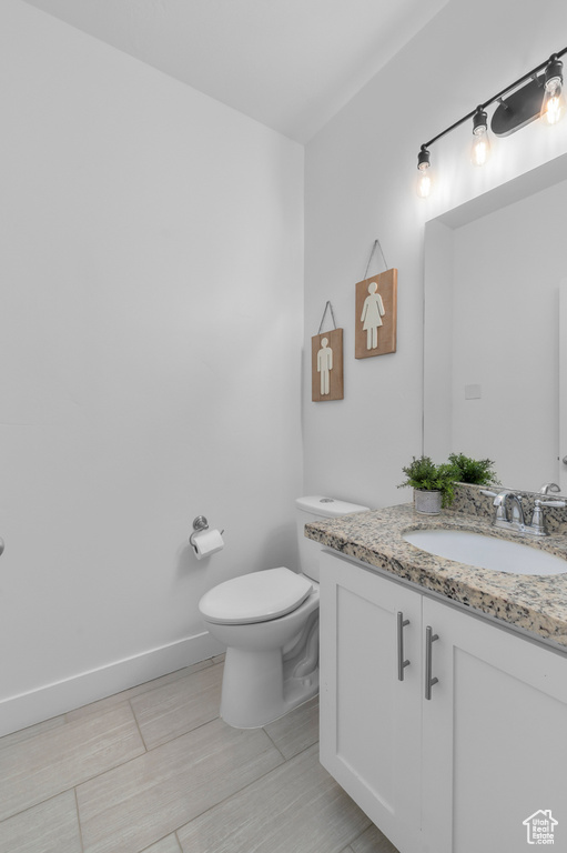 Half bathroom with vanity and toilet