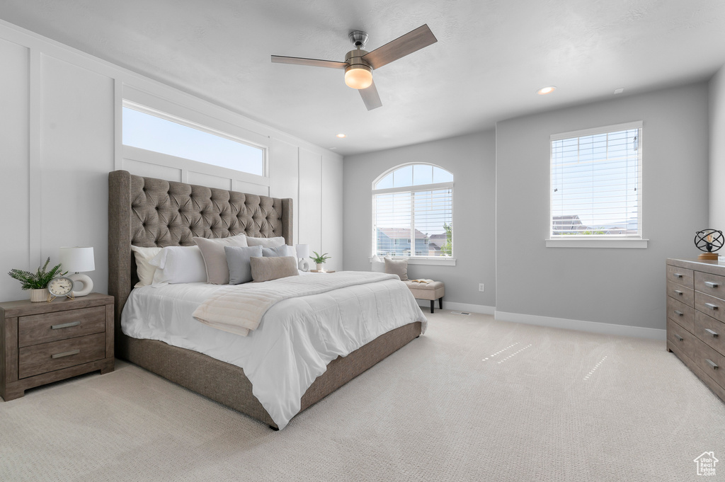 Bedroom with light colored carpet, ceiling fan, and recessed lighting