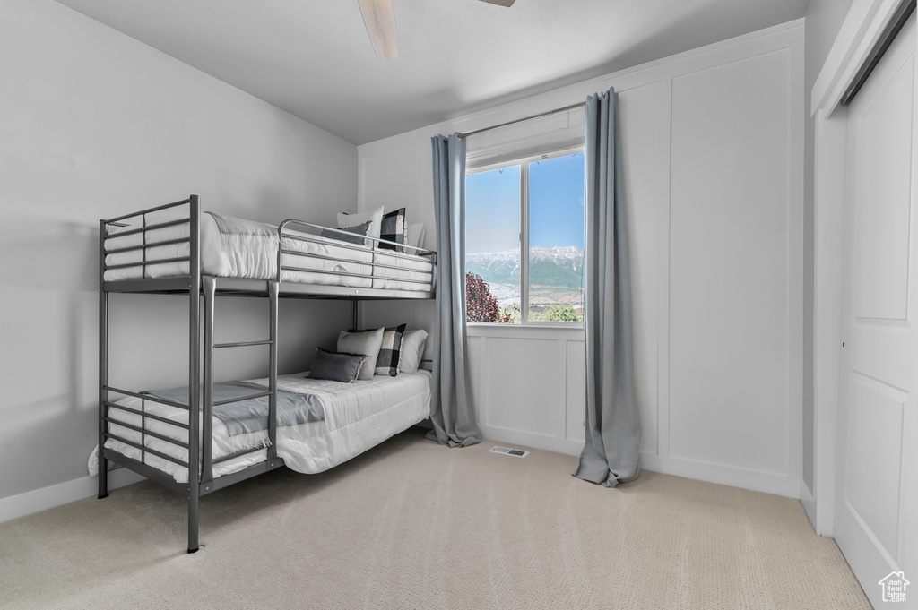 Carpeted bedroom with ceiling fan and baseboards