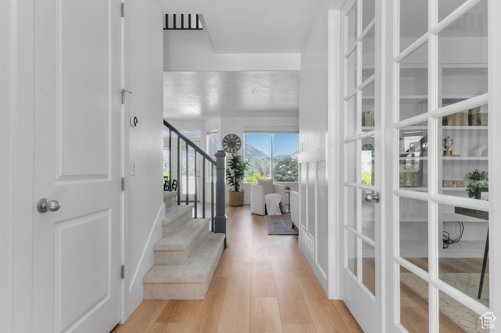 Foyer entrance with light wood-type flooring, stairs, and french doors
