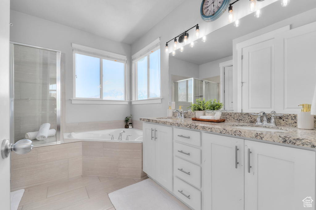 Bathroom with double vanity, a stall shower, a bath, and tile patterned floors