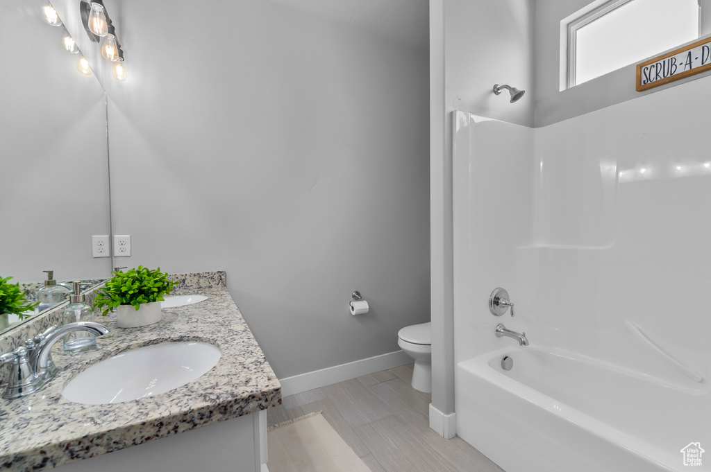 Full bath featuring double vanity and shower / bath combination