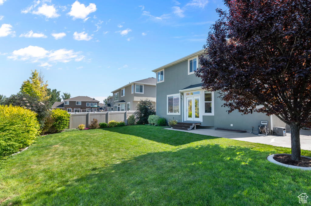 View of yard with french doors, a patio area, entry steps, and a residential view