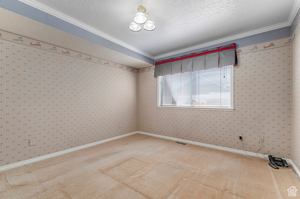 Unfurnished room featuring carpet floors, ornamental molding, and wallpapered walls