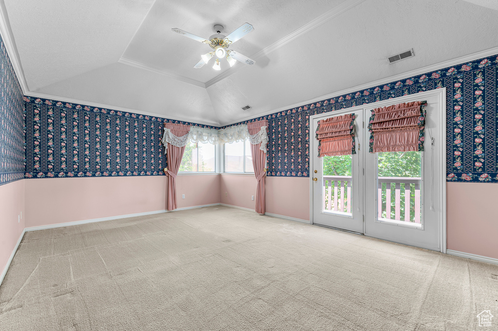 Unfurnished room with a ceiling fan, ornamental molding, a raised ceiling, carpet, and wallpapered walls