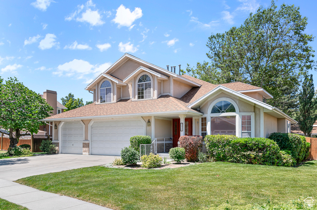 Traditional-style home with stucco siding, driveway, and a shingled roof