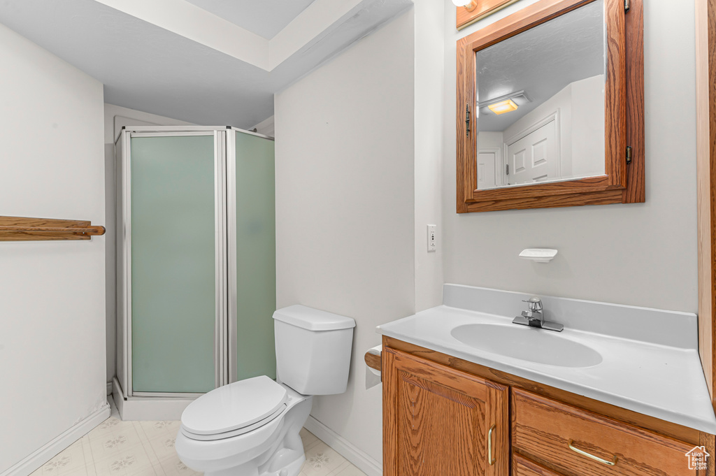 Bathroom with vanity, a stall shower, and tile patterned floors