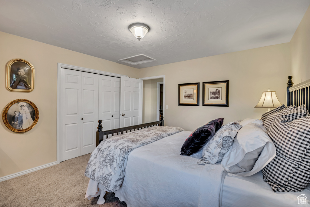 Carpeted bedroom featuring attic access and a closet