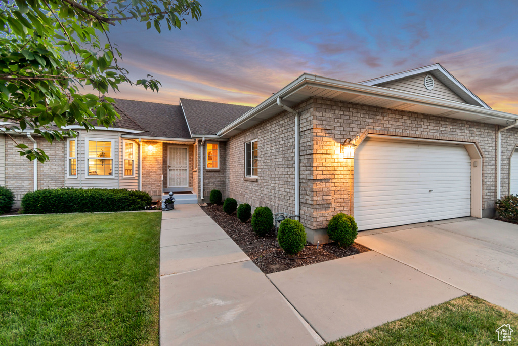 Ranch-style house with an attached garage, a front lawn, brick siding, and concrete driveway