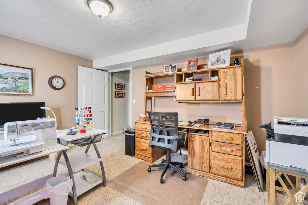 Office space with a textured ceiling and baseboards