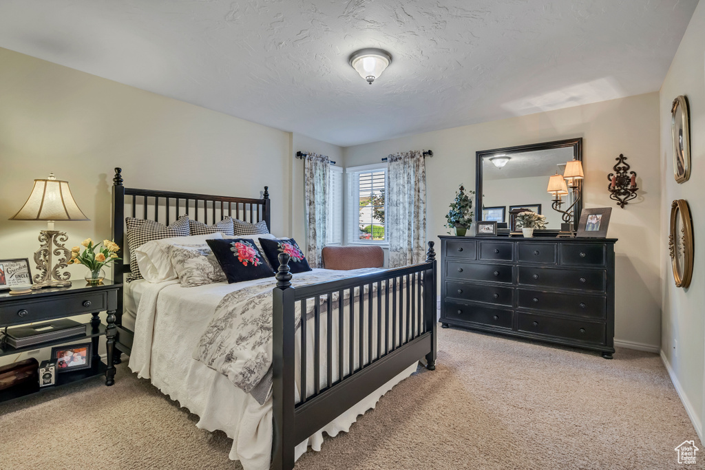 Bedroom featuring light colored carpet and a textured ceiling