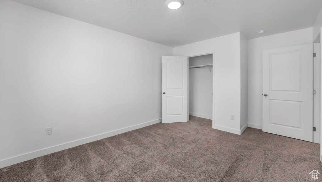 Unfurnished bedroom featuring carpet flooring and a closet