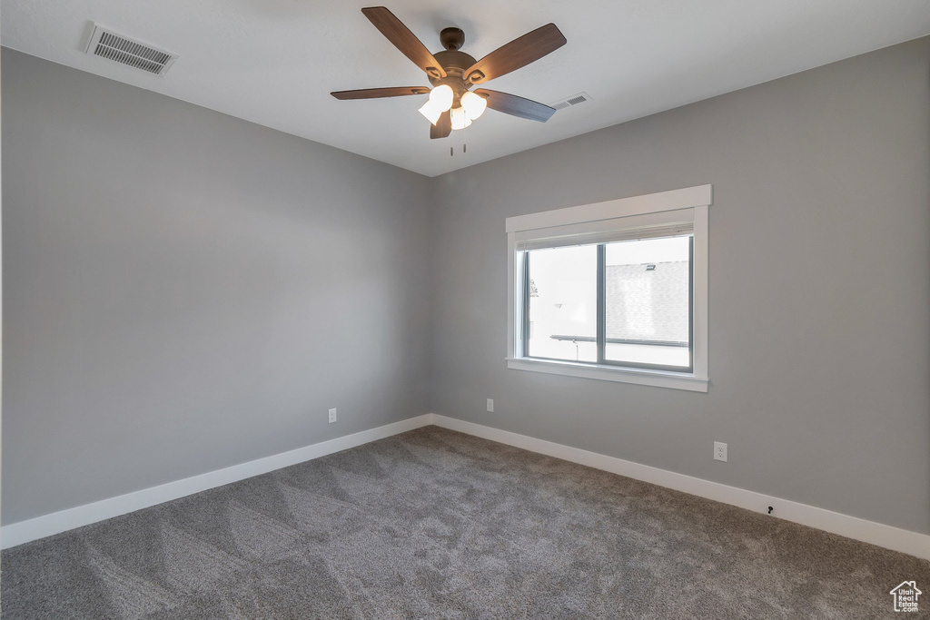 Spare room with carpet floors and a ceiling fan