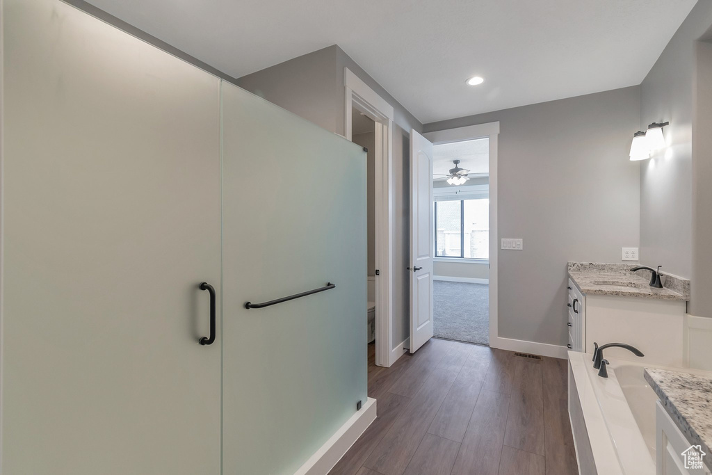 Full bathroom featuring vanity, wood finished floors, recessed lighting, a stall shower, and ceiling fan