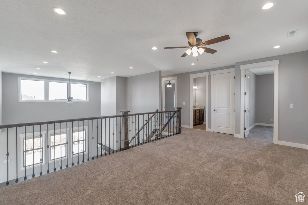 Carpeted spare room featuring a ceiling fan and recessed lighting