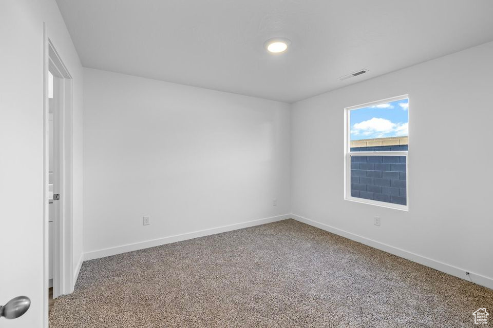 Carpeted empty room with baseboards