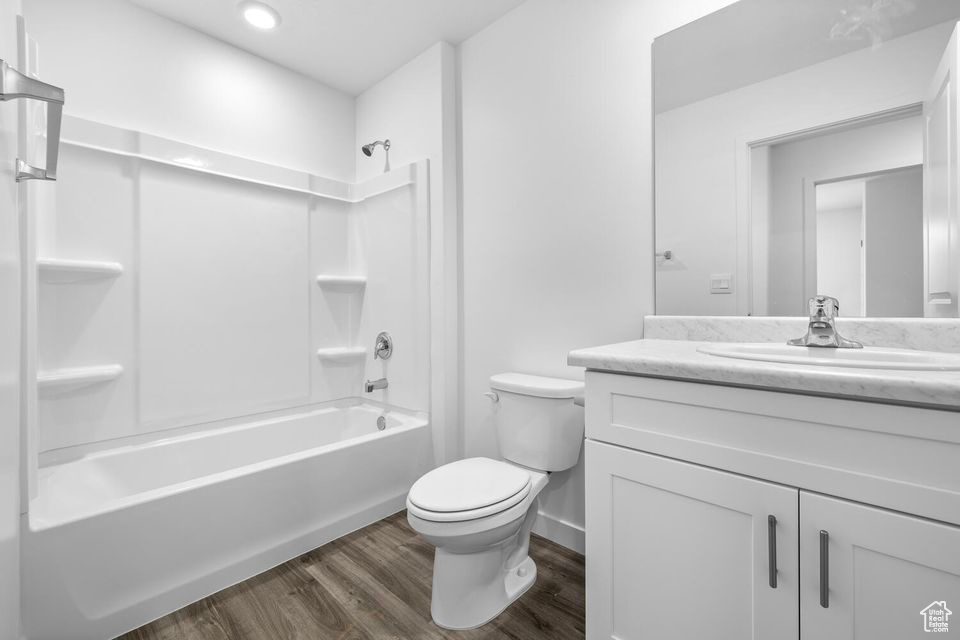 Bathroom featuring vanity, bathtub / shower combination, and wood finished floors
