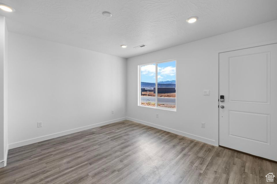 Empty room with wood finished floors and recessed lighting