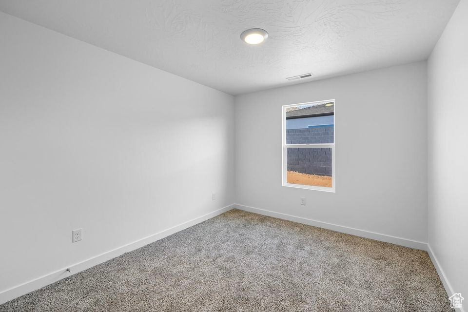 Unfurnished room with carpet floors and a textured ceiling