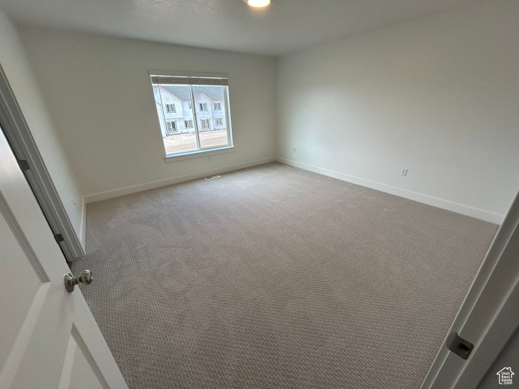 Carpeted empty room featuring baseboards