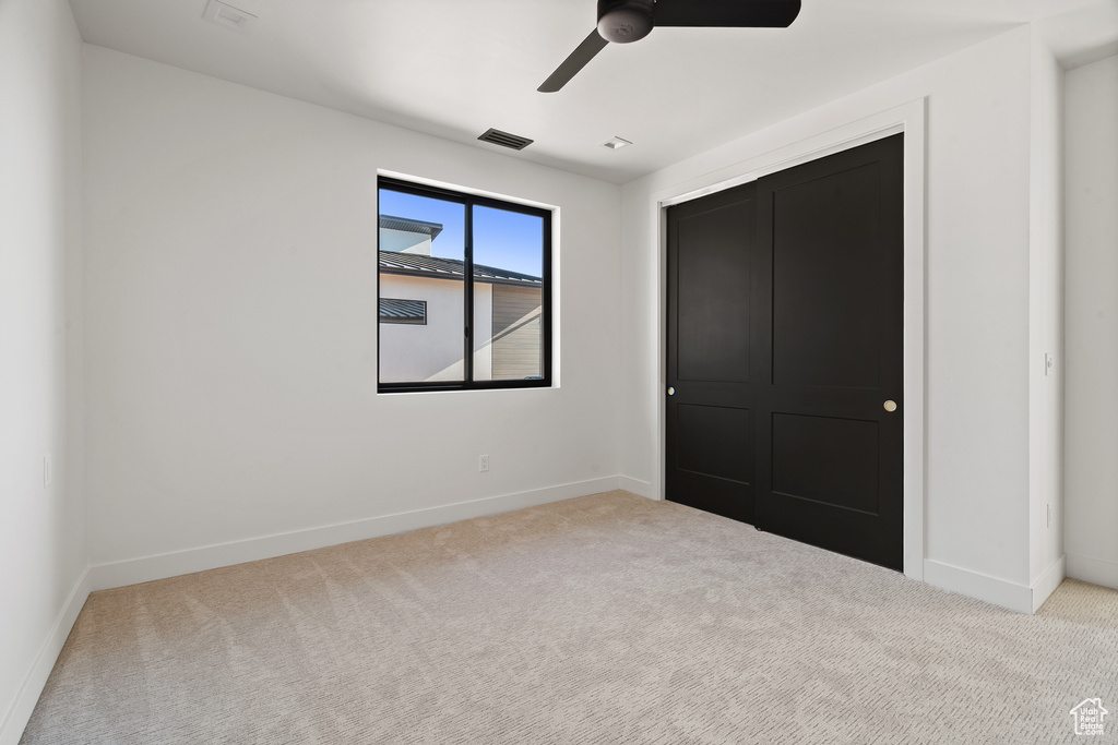 Unfurnished bedroom with carpet and a ceiling fan