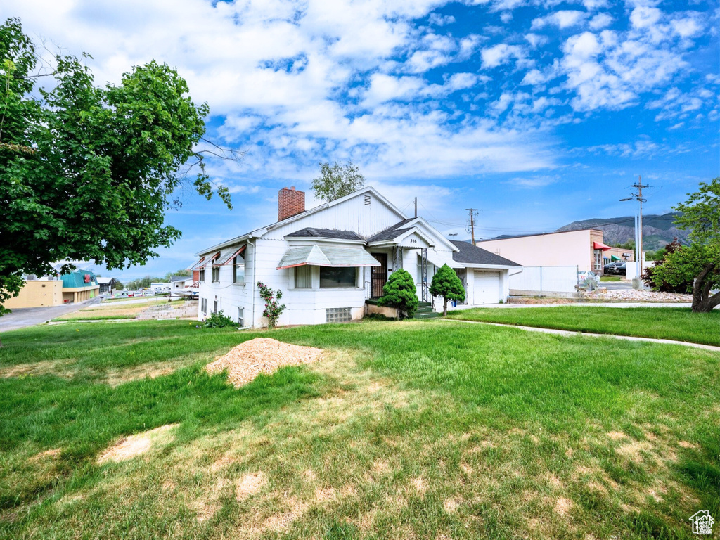 Bungalow featuring a chimney and a front yard