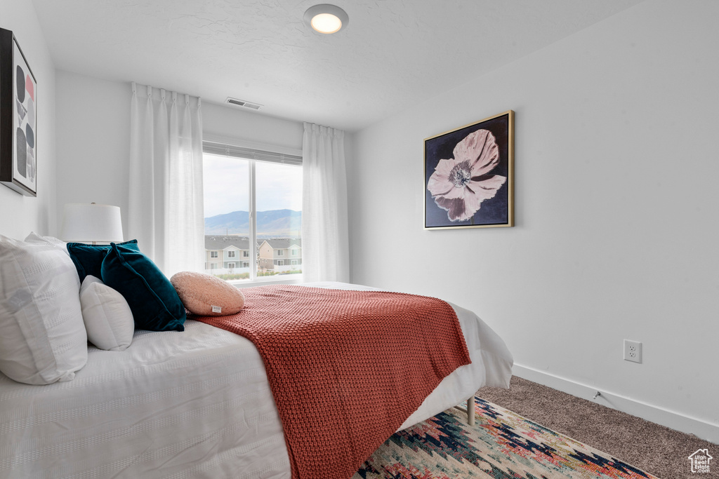 Bedroom with carpet and a mountain view