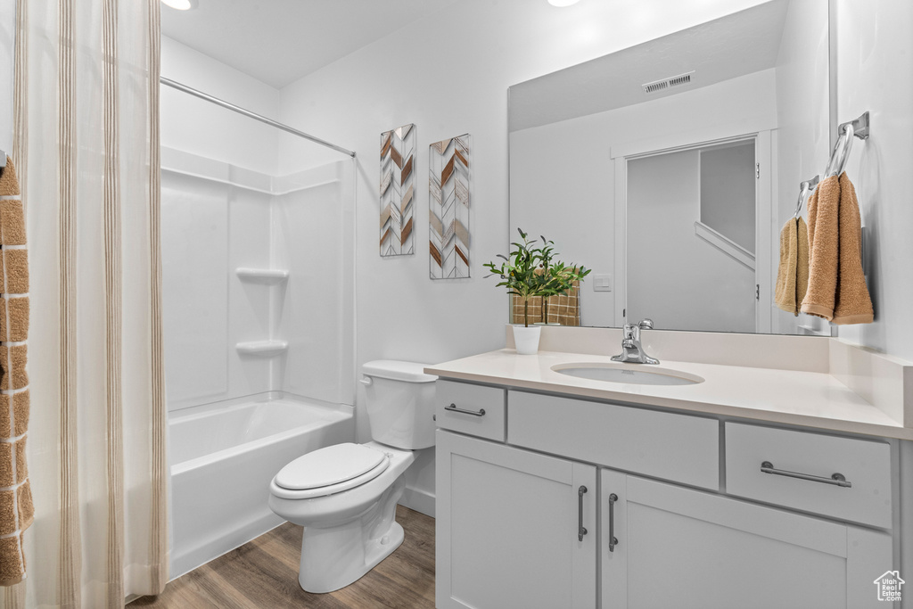 Bathroom with vanity, wood finished floors, and bathtub / shower combination
