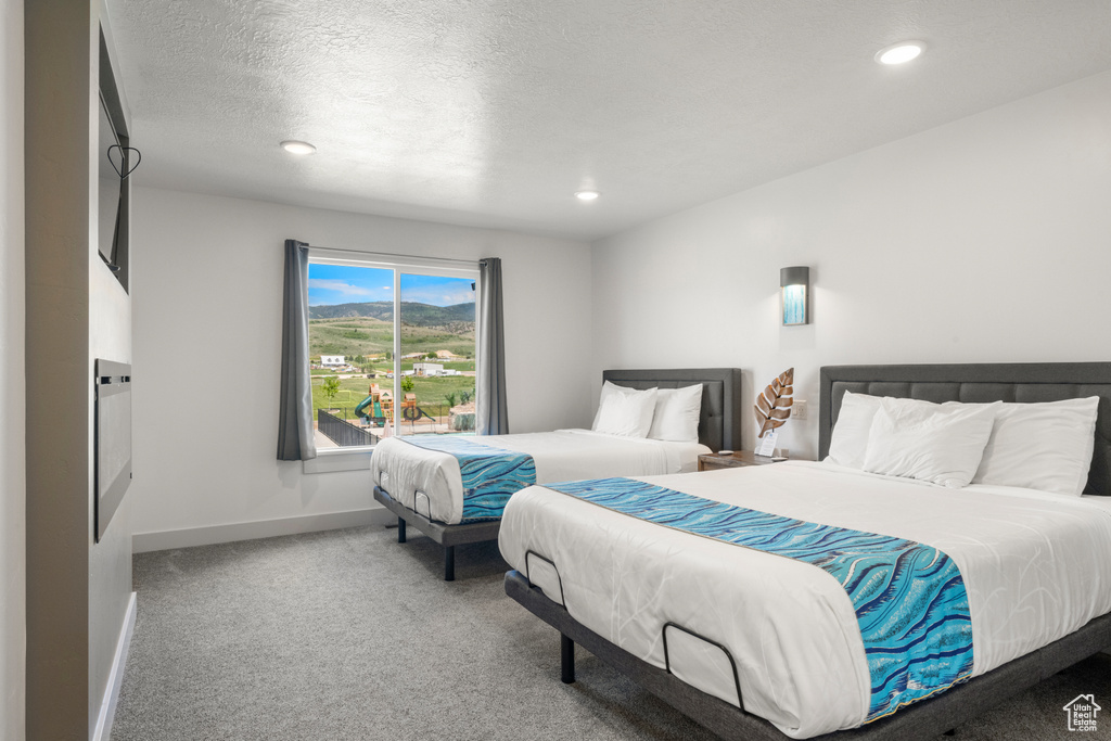Bedroom with carpet, recessed lighting, and a textured ceiling