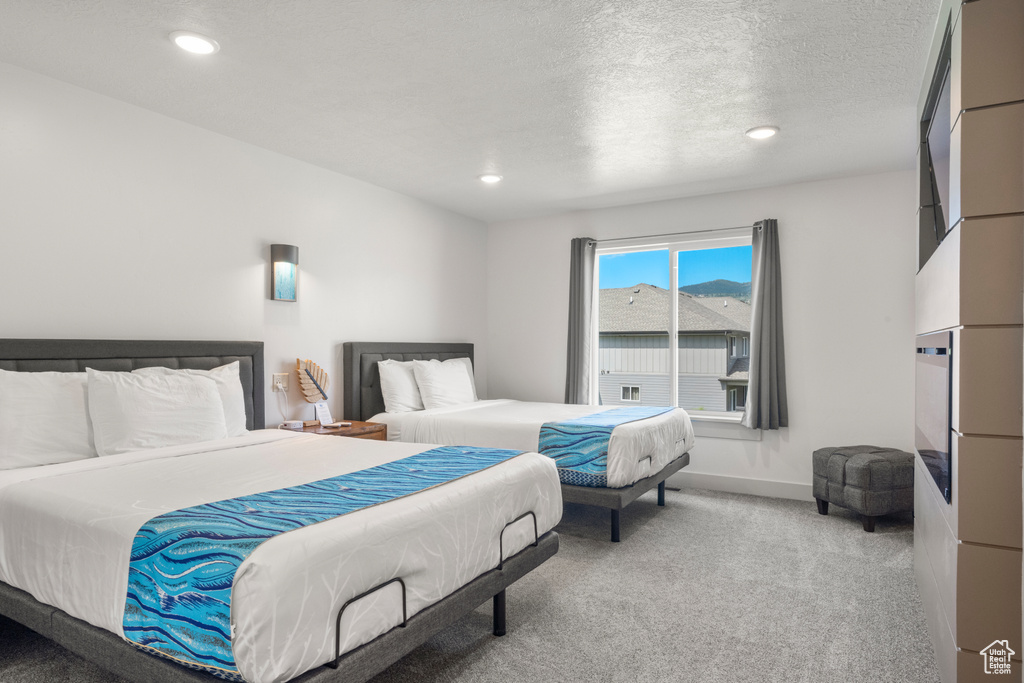 Carpeted bedroom with recessed lighting and a textured ceiling