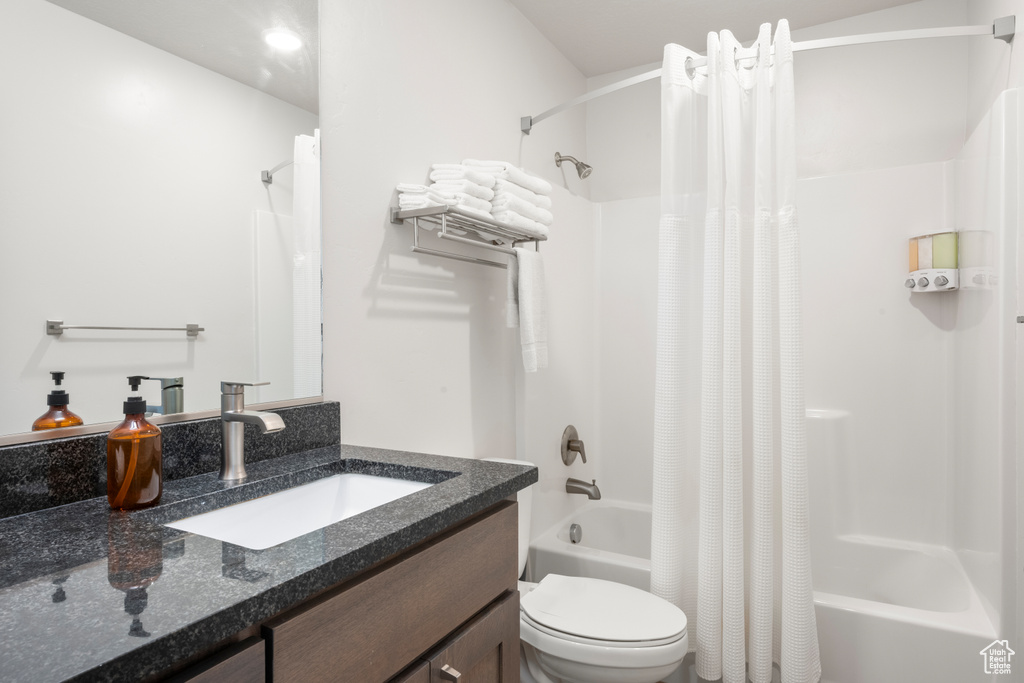 Bathroom with shower / bath combination with curtain and vanity
