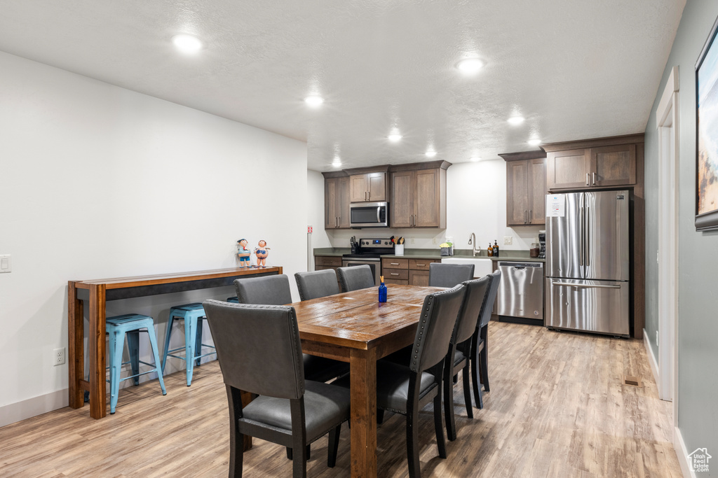Dining room with light wood-type flooring and recessed lighting