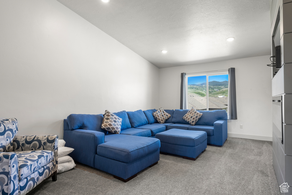 Carpeted living room featuring recessed lighting and vaulted ceiling