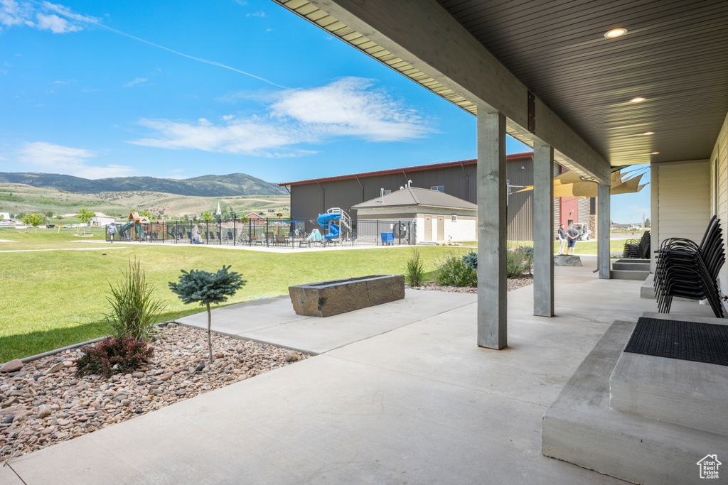 View of patio with a mountain view and a playground