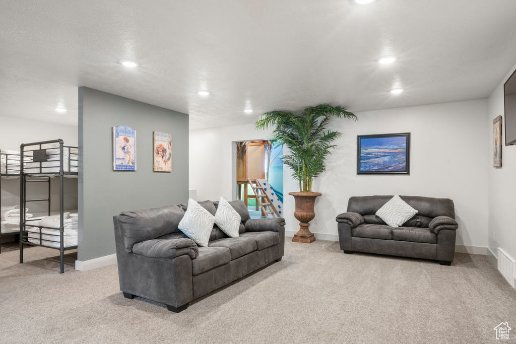 Carpeted living area with recessed lighting and baseboards