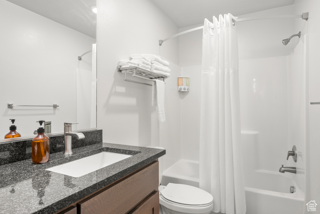 Full bathroom with shower / tub combo with curtain and vanity