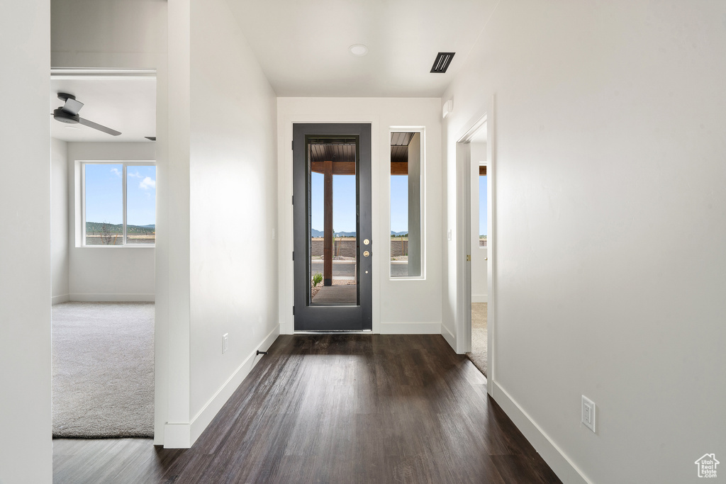Foyer with dark wood-style floors and ceiling fan