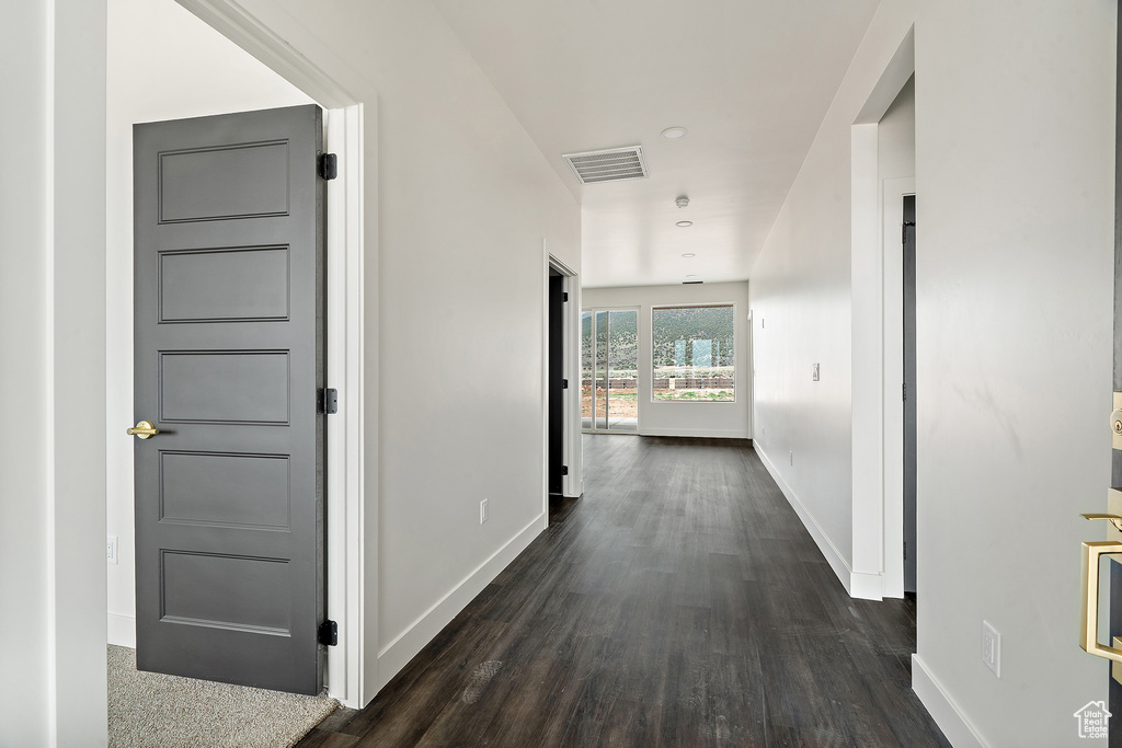 Hallway with baseboards and dark wood finished floors