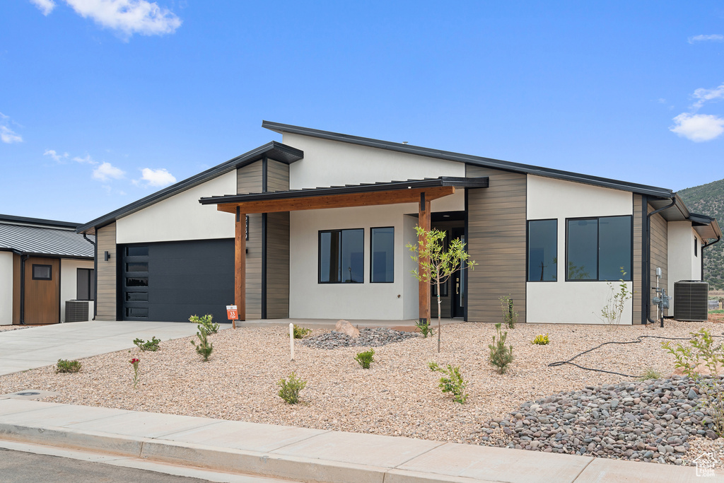 Contemporary home featuring an attached garage, concrete driveway, and stucco siding