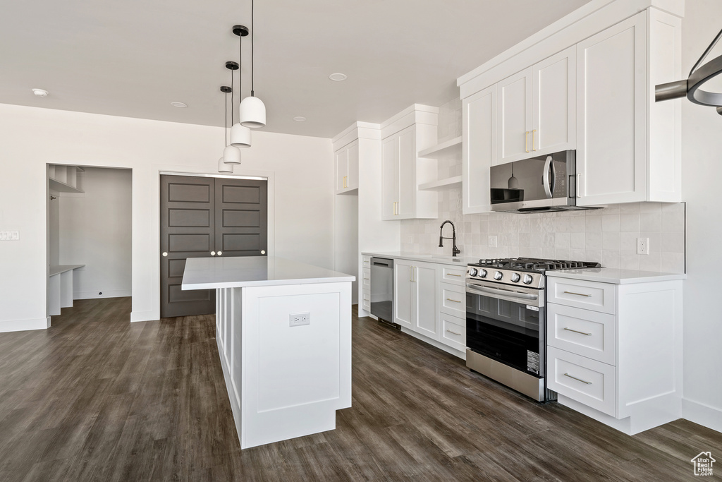 Kitchen with stainless steel appliances, backsplash, light countertops, and open shelves