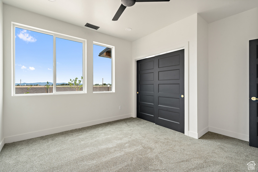 Unfurnished bedroom with carpet floors and ceiling fan
