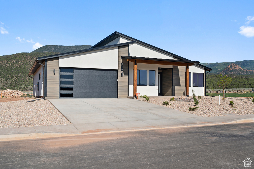 Contemporary house with a mountain view, a garage, and driveway