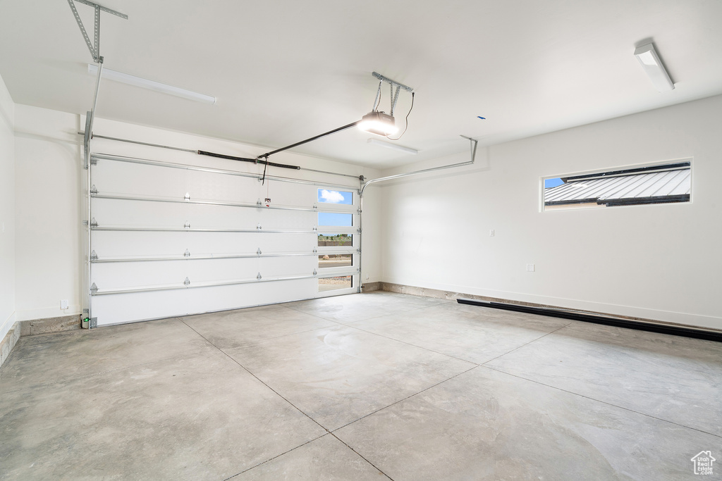 Garage with baseboards and a garage door opener