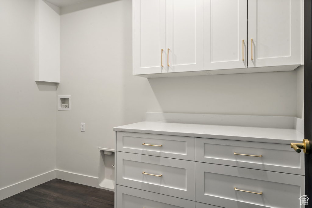 Laundry area with cabinet space, hookup for a washing machine, and dark wood finished floors