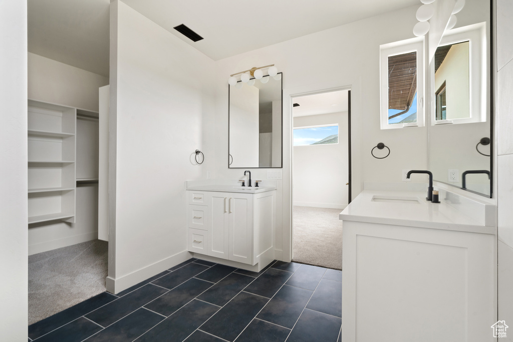 Full bathroom featuring two vanities and tile patterned flooring