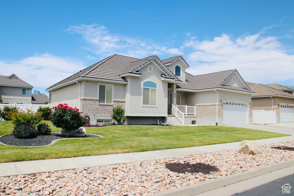View of front of house featuring stucco siding, a garage, concrete driveway, and a tile roof
